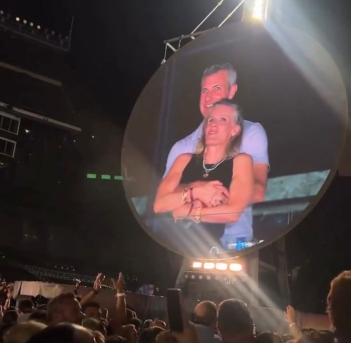 Couple embracing at Coldplay concert with crowd below, related to Coldplay HR exec mortgage news. Couple embracing at Coldplay concert with crowd below, related to Coldplay HR exec mortgage news.