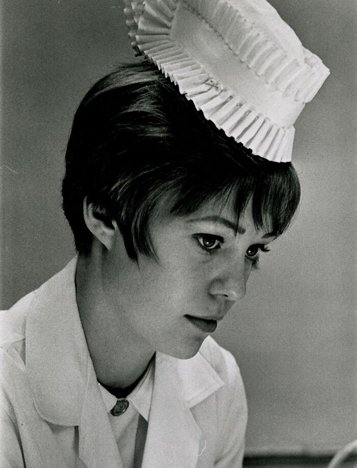 Vintage photo of a nurse in traditional uniform and hat, embodying healing and hope with a focused expression.