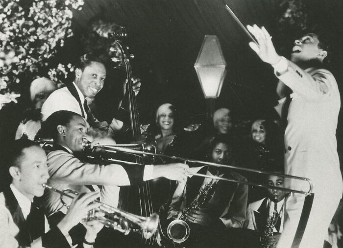 Vintage postcards showing a lively 1930s jazz band with musicians playing trumpet, trombone, and double bass in a social setting.
