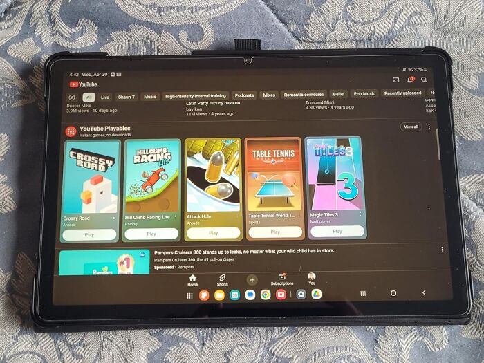 Tablet displaying YouTube Playables with arcade and sports games, highlighting Prime Day electronic deals for easy shopping.