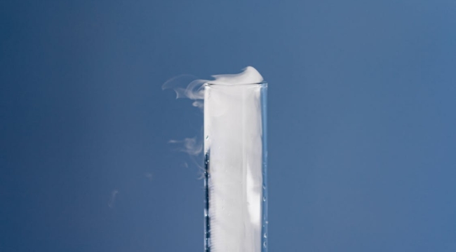 Test tube with water vapor rising, illustrating the process of water changing from liquid to gas in science.
