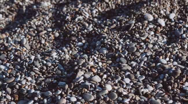 Close-up of various rocks and minerals on the ground related to general science knowledge and geology studies.