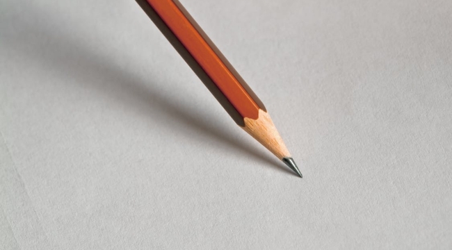 Close-up of an orange pencil tip on white paper illustrating general science knowledge about graphite in pencils.
