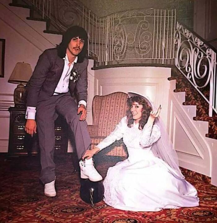 Vintage photo of a dad in a suit with long hair and a bride showcasing old school cool style and attitude.
