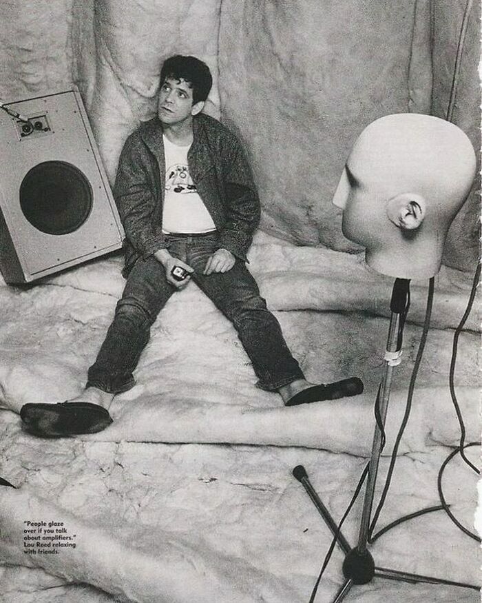 1970s rock legend Lou Reed relaxing in a studio surrounded by sound equipment and a mannequin head.