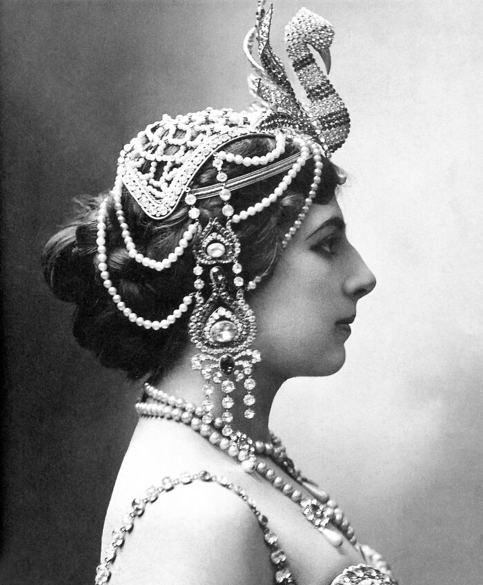 Black and white profile of a courtesan wearing ornate pearl and jewel headpieces and jewelry, representing power players in history.