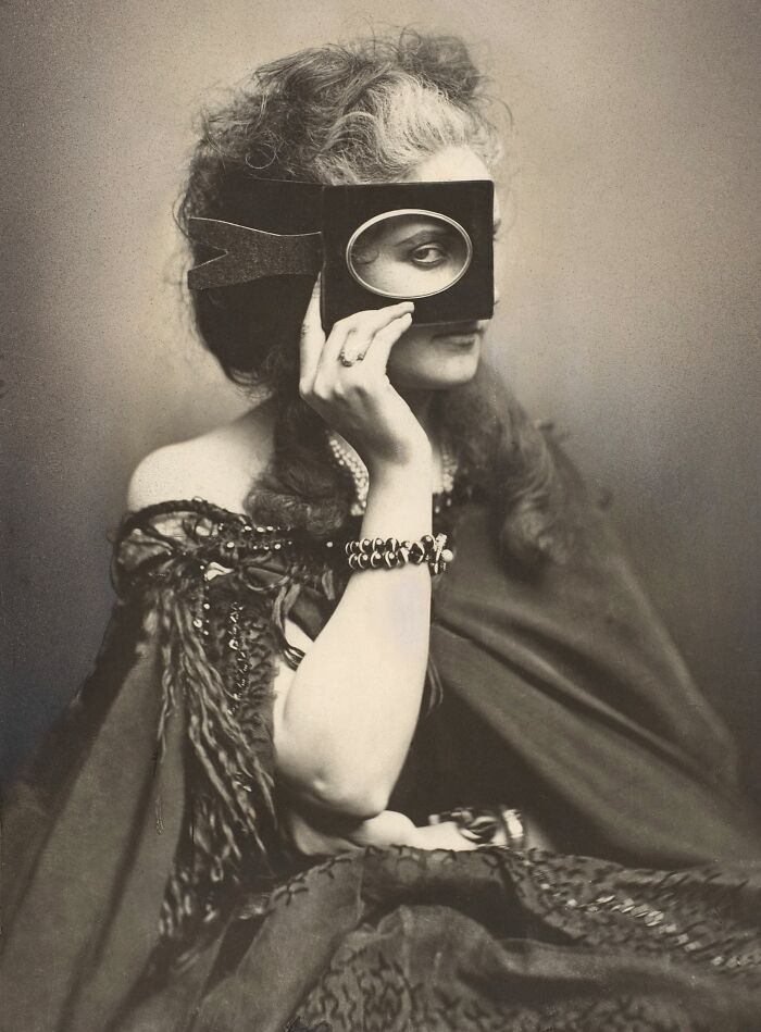 Victorian courtesan in elaborate dress holding a handheld mask over one eye, portraying a power player in history.