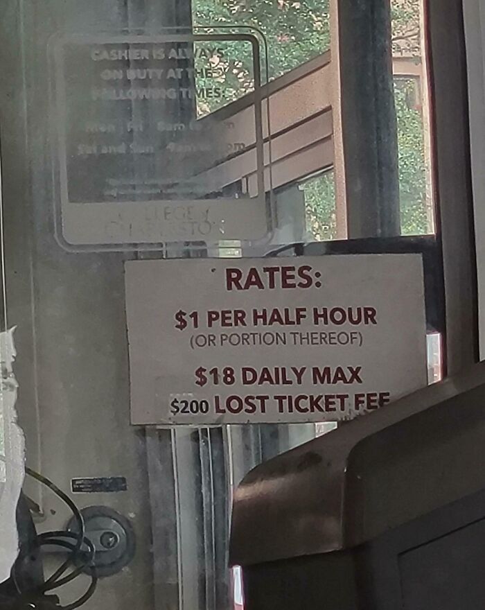 Parking rates sign showing $1 per half hour fee, $18 daily max, and $200 lost ticket fee, highlighting ridiculous fees.