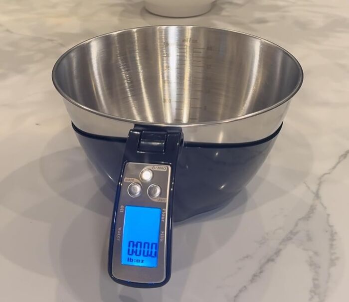 Digital kitchen scale with a stainless steel bowl on marble countertop, showcasing accurate under-the-radar finds.