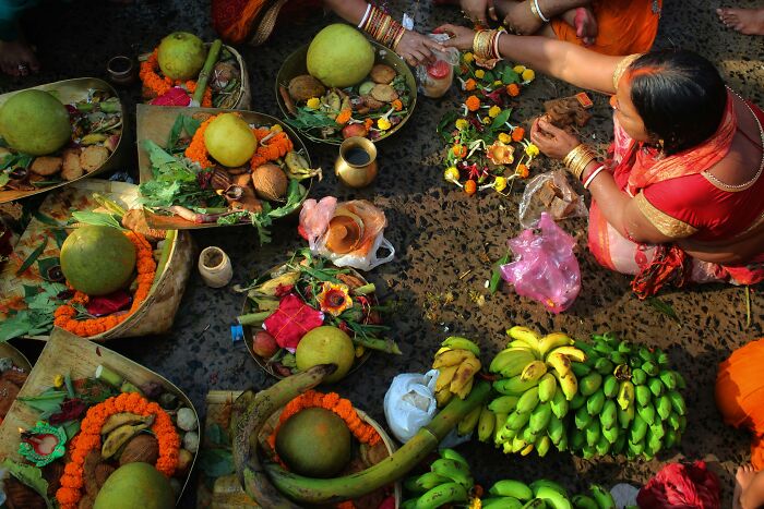 Women preparing traditional religious offerings with fruits and flowers during a cultural ceremony addressing Jesus wrote the Bible myths.