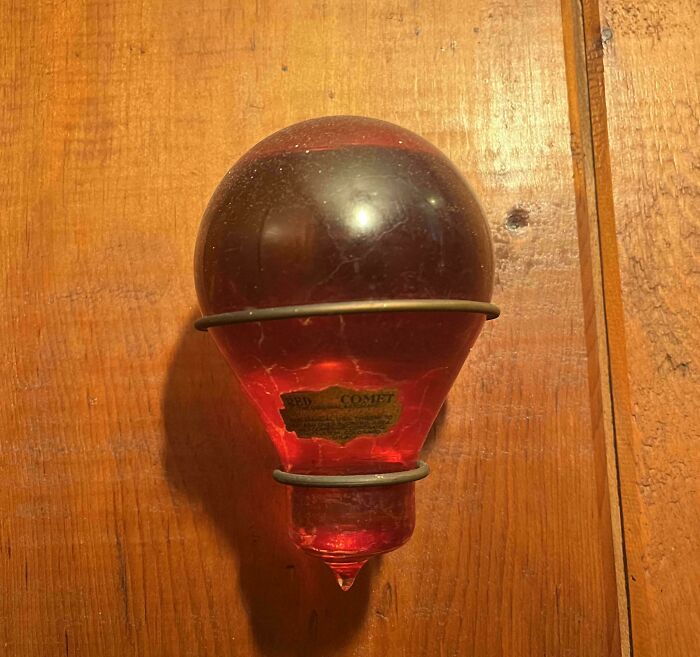 Antique red glass vintage old thing hanging on wooden wall, showcasing beautiful old collectible item.