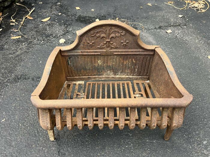 Rusty vintage cast iron fireplace grate with ornate design, showcasing one of the most interesting and beautiful old things owned.