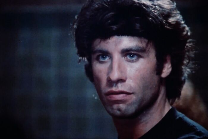 Close-up of a man with dark hair and intense expression in a dimly lit scene from the worst movie sequels cinematic crimes.