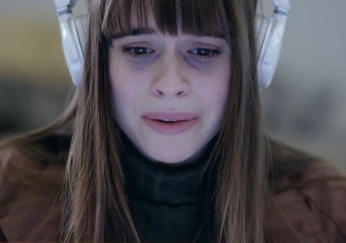 Young woman wearing headphones looking upset, illustrating cinematic crimes in worst movie sequels scenes.