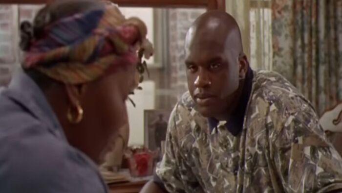 Scene from one of the worst movies of all time showing two characters in a tense conversation indoors.