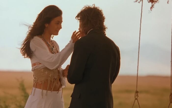 A romantic scene between a woman and a man in an outdoor setting, highlighting cinematic crimes in movie sequels.