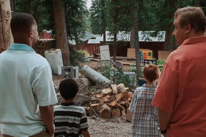 Four people stand facing a cluttered outdoor scene, illustrating a cinematic crimes moment from worst movie sequels.