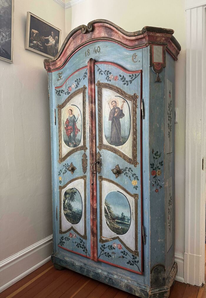Antique painted wooden wardrobe from 1840 with religious and landscape artwork, showcasing beautiful old collectible furniture.