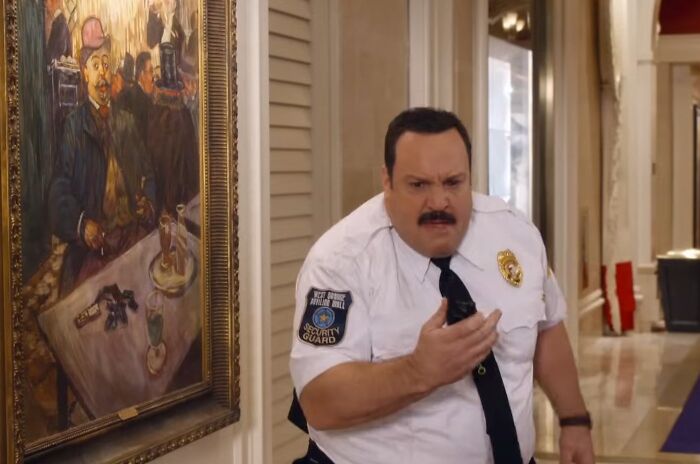 Actor in a security guard uniform reacting dramatically, representing cinematic crimes in worst movie sequels.