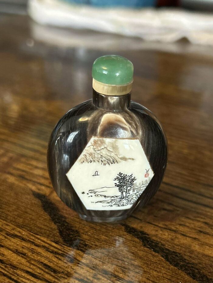 Small vintage decorative bottle with a painted landscape and green stopper, showcasing beautiful old collectibles.