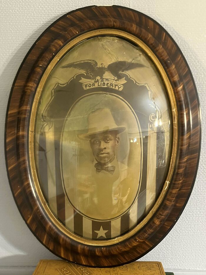 Oval vintage framed photo of a man wearing a hat and bow tie, showcasing interesting and beautiful old things collection.