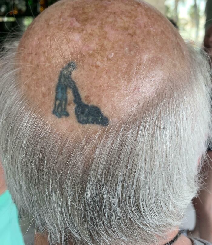 Bald man with a vacuum cleaner tattoo on his head, illustrating suspiciously unbothered attitude toward appearance.