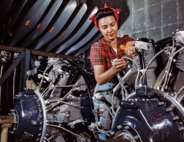 Woman at work during WWII assembling aircraft engine parts in a factory, showcasing bold and brilliant women at work.