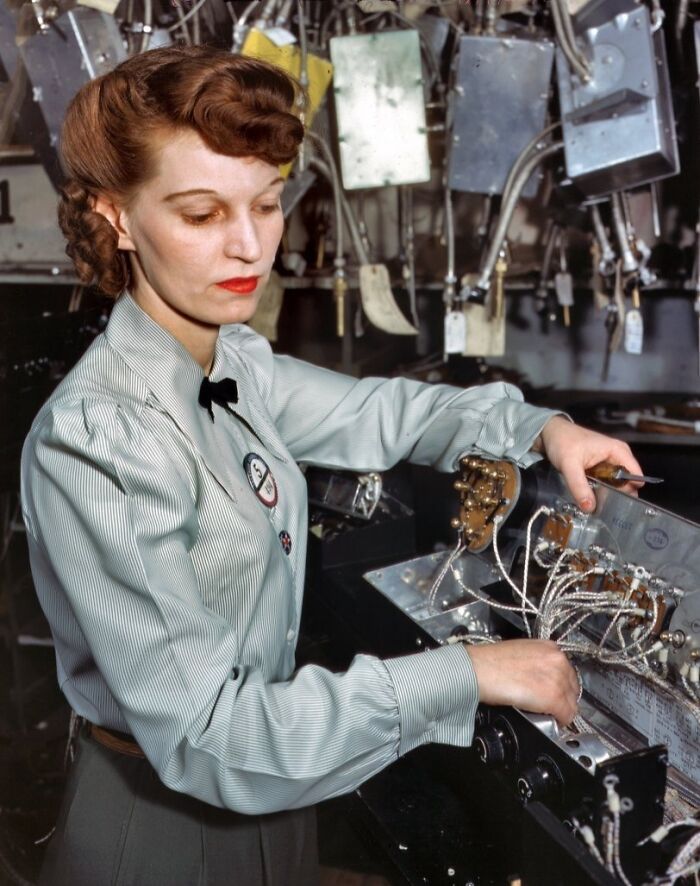 Woman at work during WWII, operating complex machinery, showcasing the bold and brilliant world of women in industry.