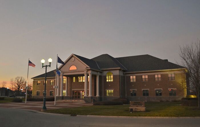 A large brick building at dusk with American flags and street lamps, representing best places to live in the USA.