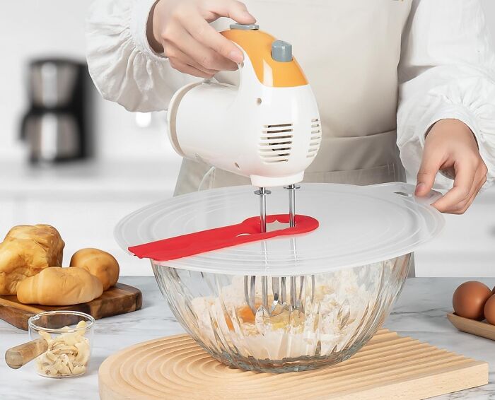 Hand mixer in use with a splash guard cover, one of the brilliant kitchen items worth the counter space.