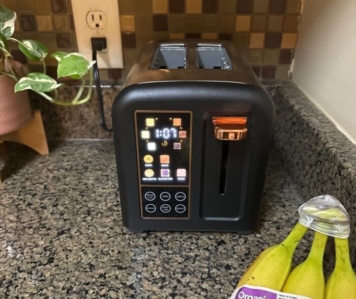 Modern sleek toaster on kitchen counter showcasing brilliant kitchen items worth the counter space next to bananas and plant.