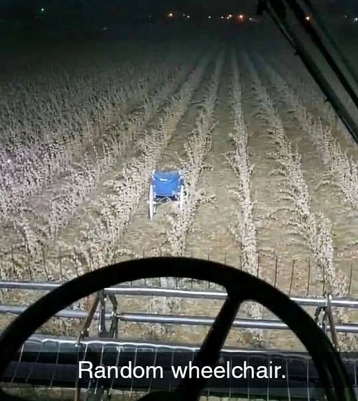 View from tractor at night showing a random wheelchair in the middle of a field, a cursed image so unhinged and eerie.