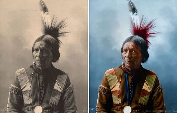Colorized historical picture of a Native American man in traditional attire with a feathered headdress and medallion necklace.