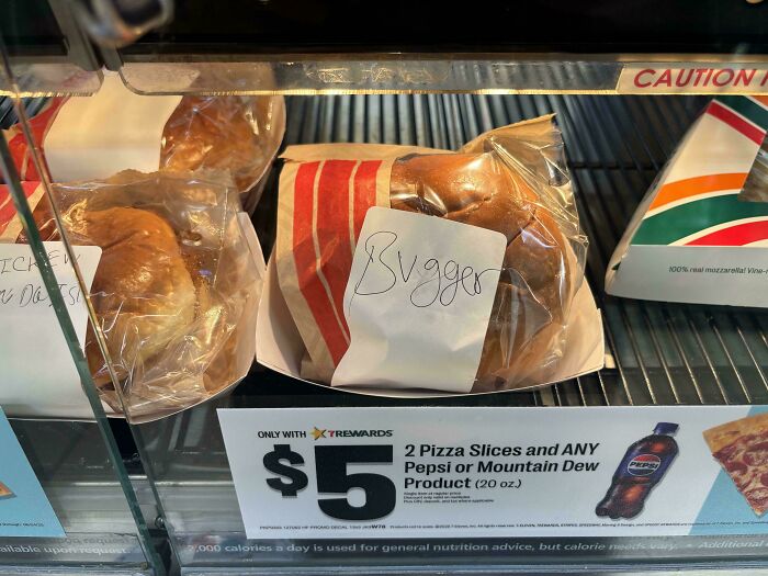 Handwritten typo labeled burger as "bygger" in a food display, highlighting amusing spelling mistakes and typos.