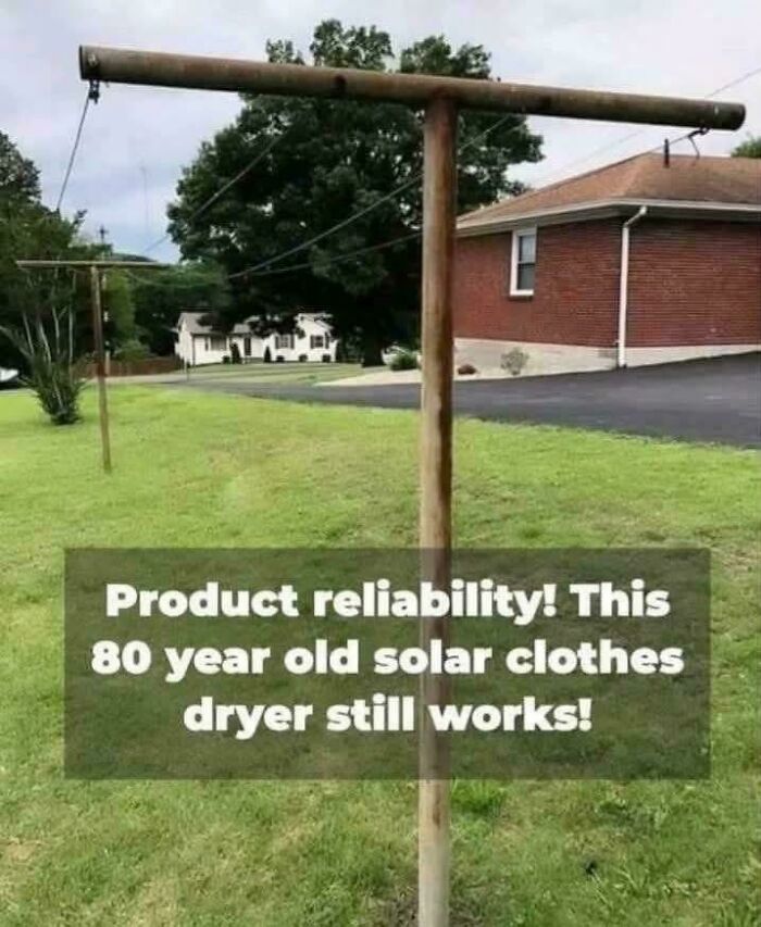Old solar clothes dryer outdoors on green lawn near brick house, showcasing nostalgic product reliability and longevity.