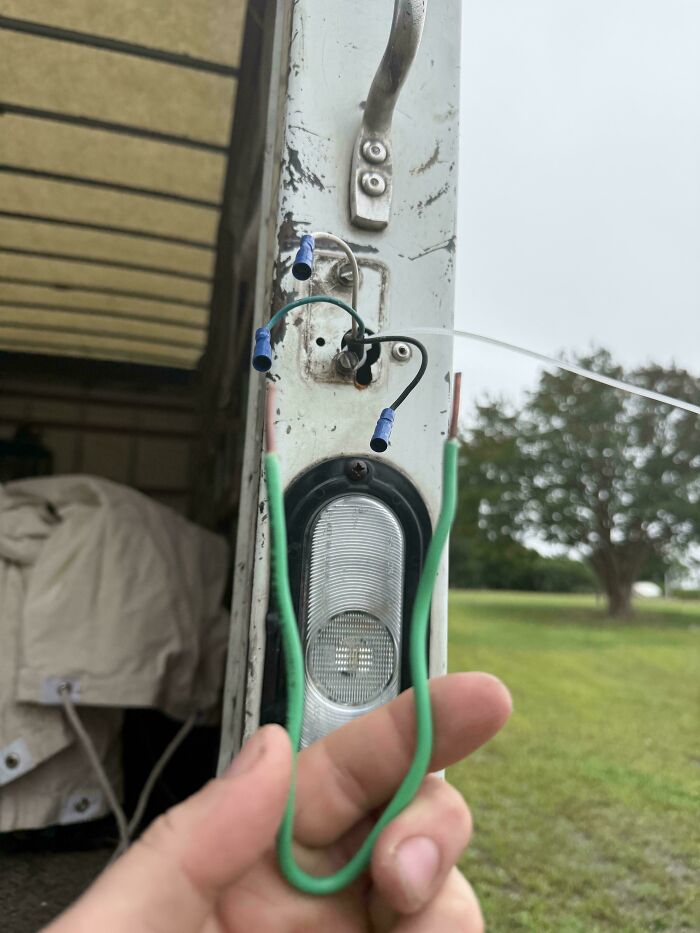 Exposed and improperly connected electrical wires on a truck door showing employee safety protocol violations and dangerous decisions.