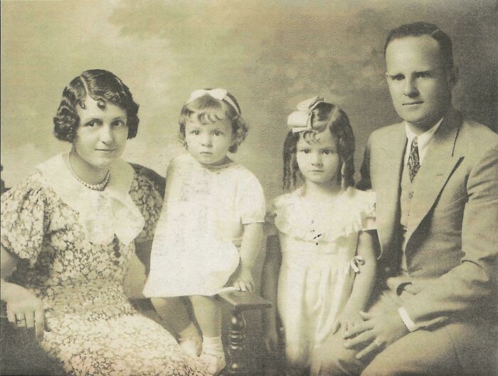 Vintage black and white portrait of a family with parents and two children, candid glimpses into the past history photo.