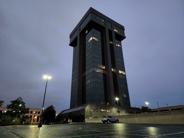 Dark ominous building at dusk with minimal lights, fitting the theme of evil buildings from horror movies.