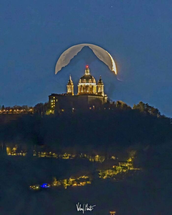 Illuminated building with an eerie crescent moon shape creating an evil buildings vibe straight out of horror movies at night.