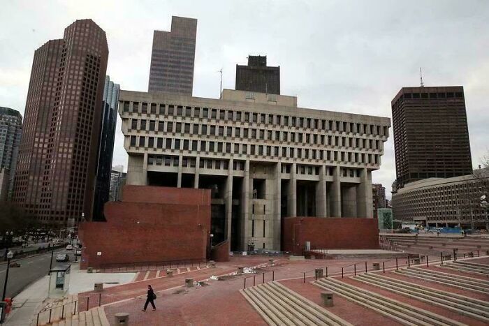 Brutalist architecture of an evil building with imposing concrete and brick design in an urban cityscape under gray skies.