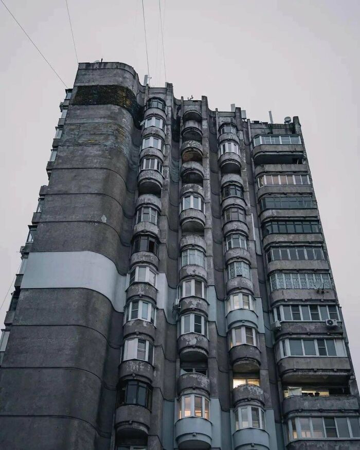 Tall creepy concrete building with rounded balconies and eerie appearance, resembling evil buildings from horror movies.