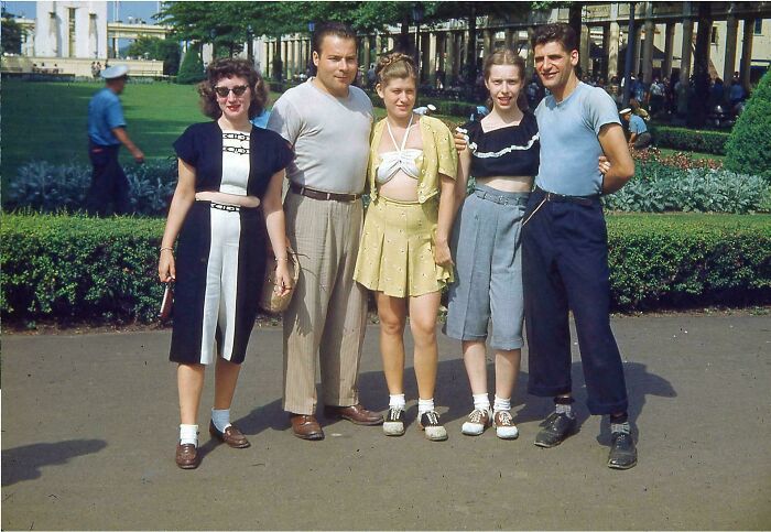 Group of five young adults posing outdoors in casual vintage clothes, offering a candid glimpse into the past.
