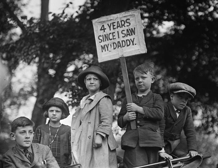 Children holding a sign about missing their father, a somber photo from history telling a gut-wrenching story of loss and waiting.