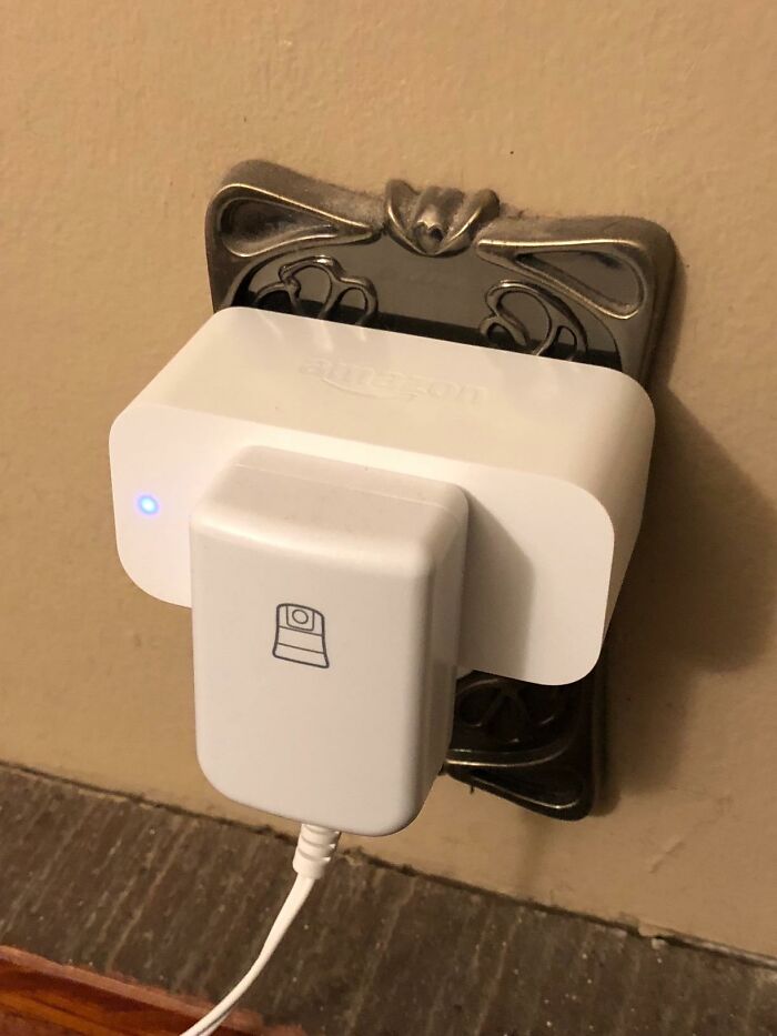 White Amazon smart plug connected to a wall outlet with a device charger, showcasing Prime Day electronic deals.