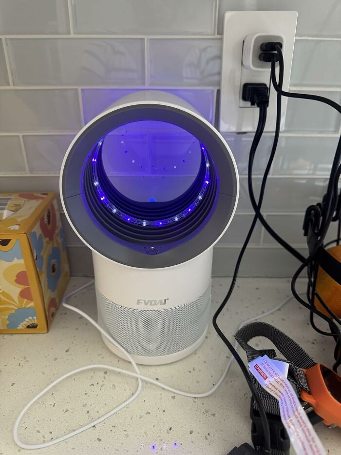 Under-the-radar finds saw a sleek, modern white air purifier with blue LED lights on a kitchen countertop.