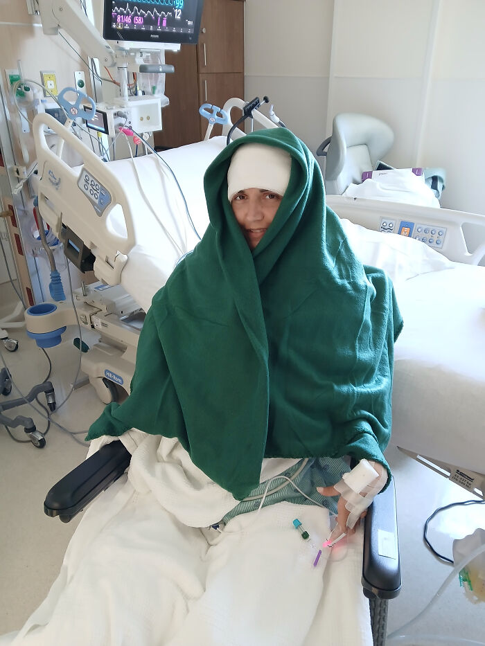 Paralyzed woman in hospital bed wrapped in green blanket demonstrating Elon Musk Neuralink brain chip technology. Paralyzed woman in hospital bed wrapped in green blanket demonstrating Elon Musk Neuralink brain chip technology.