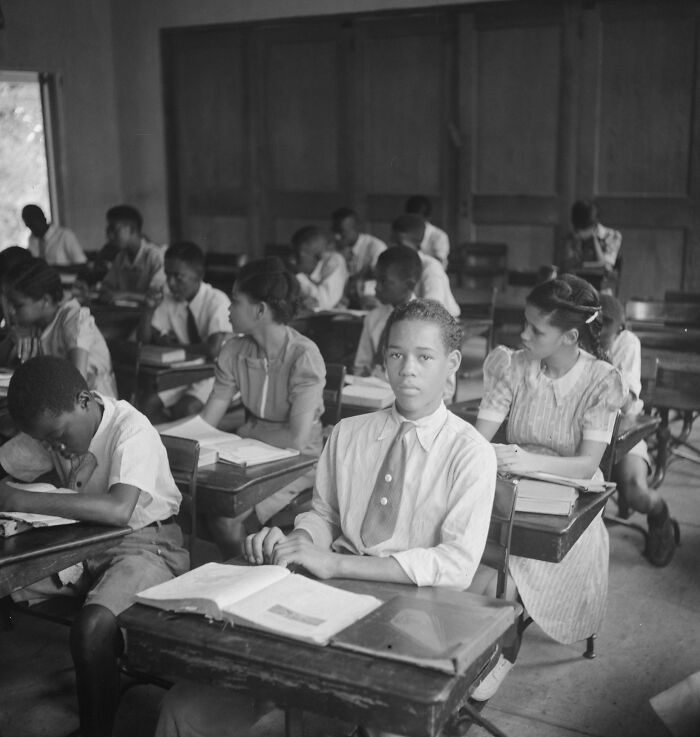 Students seated in a classroom during World War II, focused on their studies in a historic school setting.