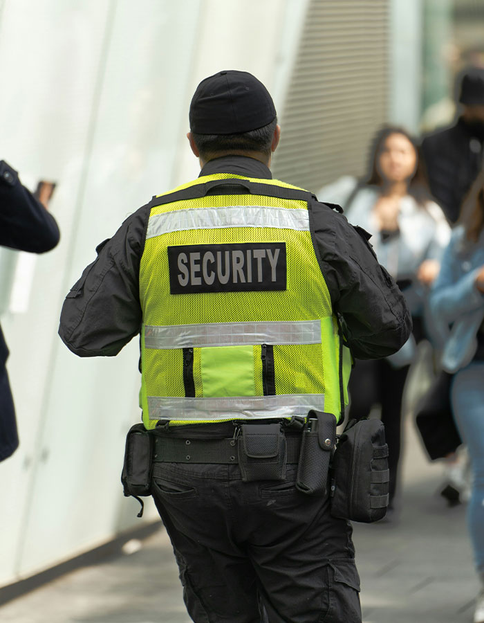 Security officer in high-visibility vest monitoring passengers after flight scare and emergency landing incident. Security officer in high-visibility vest monitoring passengers after flight scare and emergency landing incident.