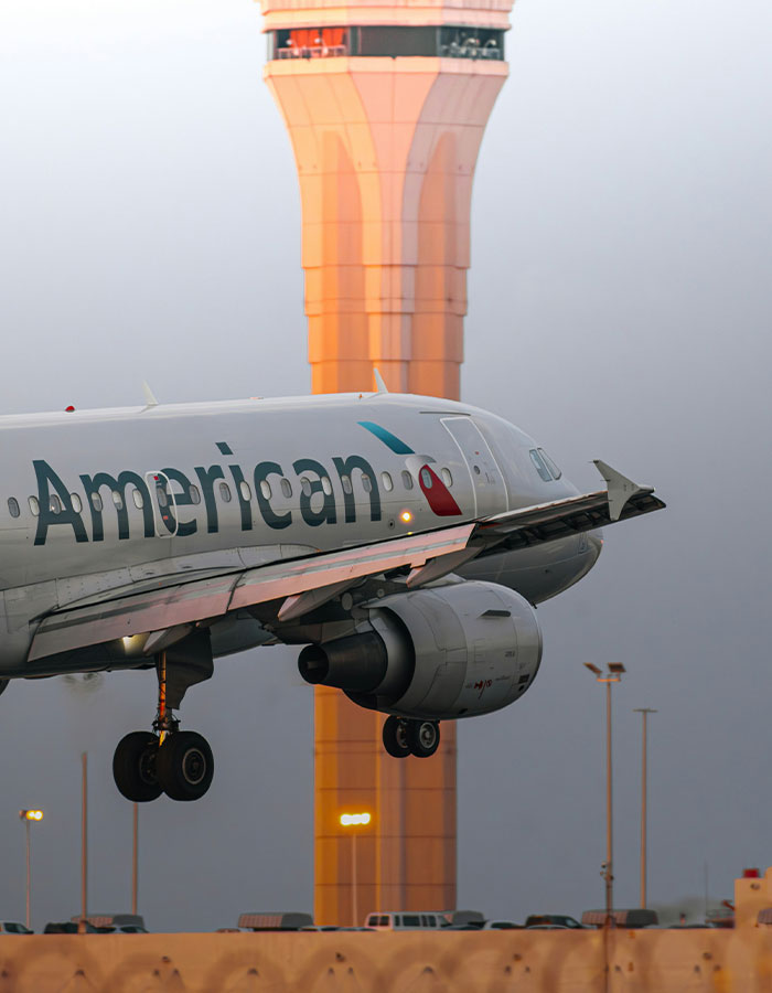 Passenger causes scare on flight leading to emergency landing with American Airlines plane near control tower at dusk. Passenger causes scare on flight leading to emergency landing with American Airlines plane near control tower at dusk.