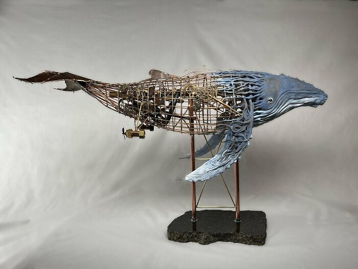 Sculpture of a whale made from scrap metal, showcasing striking animal sculptures by an innovative artist.